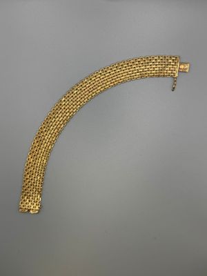 a close up of a gold bracelet on a gray surface