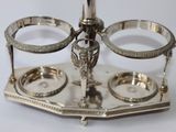 a silver plate with two cups on it on a stand