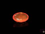 an orange diamond on a black surface with a black background