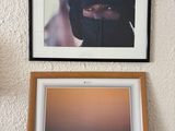 framed photograph of a woman in a black veil and a camel in the desert