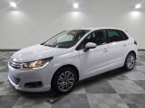 a white car is parked on a checkered floor in a garage