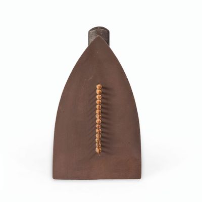 un vase marron muni d'une poignée en bois, posé sur une surface blanche
