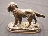 bronze statue of a dog on a wooden base on a table