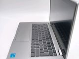 a silver laptop with a black keyboard on a white surface