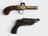 pair of old guns on a white surface with a white background