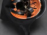 an orange and black helmet with black straps and a black hat