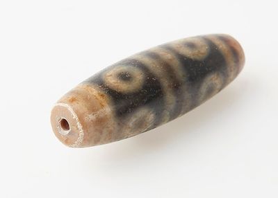 perle présentant un motif tourbillonnant marron et noir sur un fond blanc