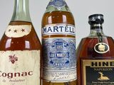 three bottles of alcohol are lined up on a white surface