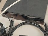 a box with a remote, a cable, and a charger on a table