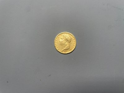 gros plan d'une pièce d'or sur une surface blanche