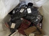 many pairs of shoes in a bag on a bed