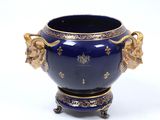a blue vase with gold decorations on it on a white surface