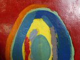 une peinture représentant un cercle aux couleurs de l'arc-en-ciel sur un fond rouge