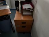 a desk with a file cabinet in the corner of the room