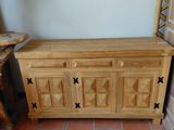 a wooden cabinet sitting on the floor next to a chair