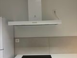 une cuisine blanche avec une plaque de cuisson noire et des placards blancs