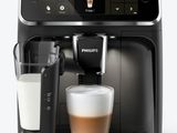 the coffee machine has a glass of milk in front of it