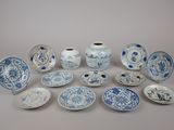 several blue and white plates and vases are arranged on a table