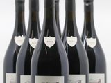 six bouteilles de vin sont alignées sur une surface blanche