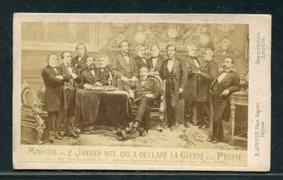 une vieille photo montrant un groupe d'hommes assis autour d'une table