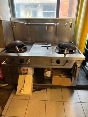 a kitchen with a stove, sink, and a window