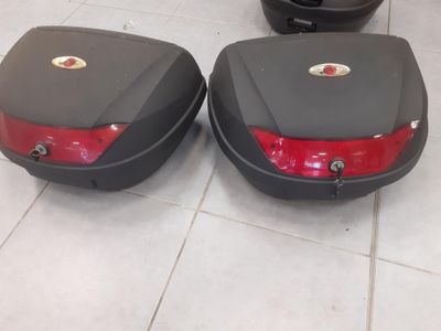 une paire de valises noires et rouges posées sur un sol carrelé