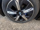 a close up of a tire on a car that is parked in a lot