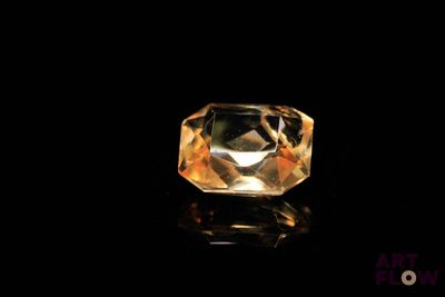 a close up of a yellow diamond on a black surface