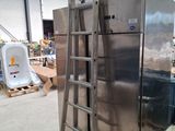 a large stainless steel refrigerator with a ladder in the middle of it