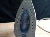 a blue and white iron sitting on a wooden table