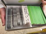 a person holding a box with a bunch of pens in it