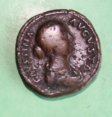 an old coin with a man on it on a green surface