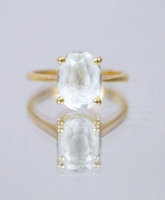 an image of a gold ring with a white topazr stone
