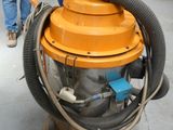 a man walking behind a machine with a hose on it