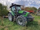 un tracteur vert garé dans l'herbe