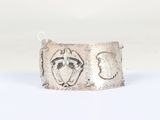 silver cuff bracelet with two faces of a man and a woman