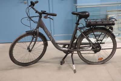 a bicycle that is parked in front of a blue wall