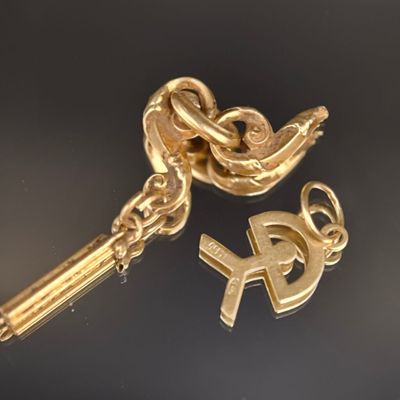 deux clés dorées et un porte-clés posés sur une surface noire