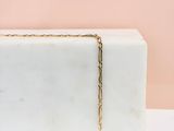une boîte en marbre blanc à laquelle est suspendue une chaîne en or