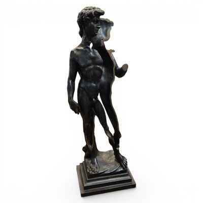 bronze statue of a boy with a pipe in his hand