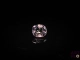 a close up of a pink diamond on a black surface