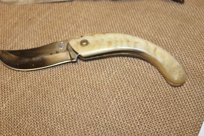 un couteau posé par terre à côté d'un autre couteau