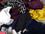 a pile of clothes that is sitting on a bed