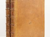 an old book sitting on top of a white table next to a white wall