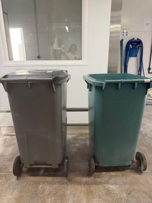 two trash cans sitting next to each other on the floor