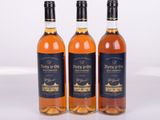 three bottles of wine sitting next to each other on a white surface