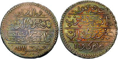 two old coins with arabic writing on them