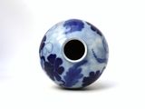 a blue and white vase with a hole in it