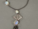a close up of a necklace on a table with a chain