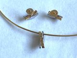 un ensemble composé d'un collier et de boucles d'oreilles posé sur une surface blanche